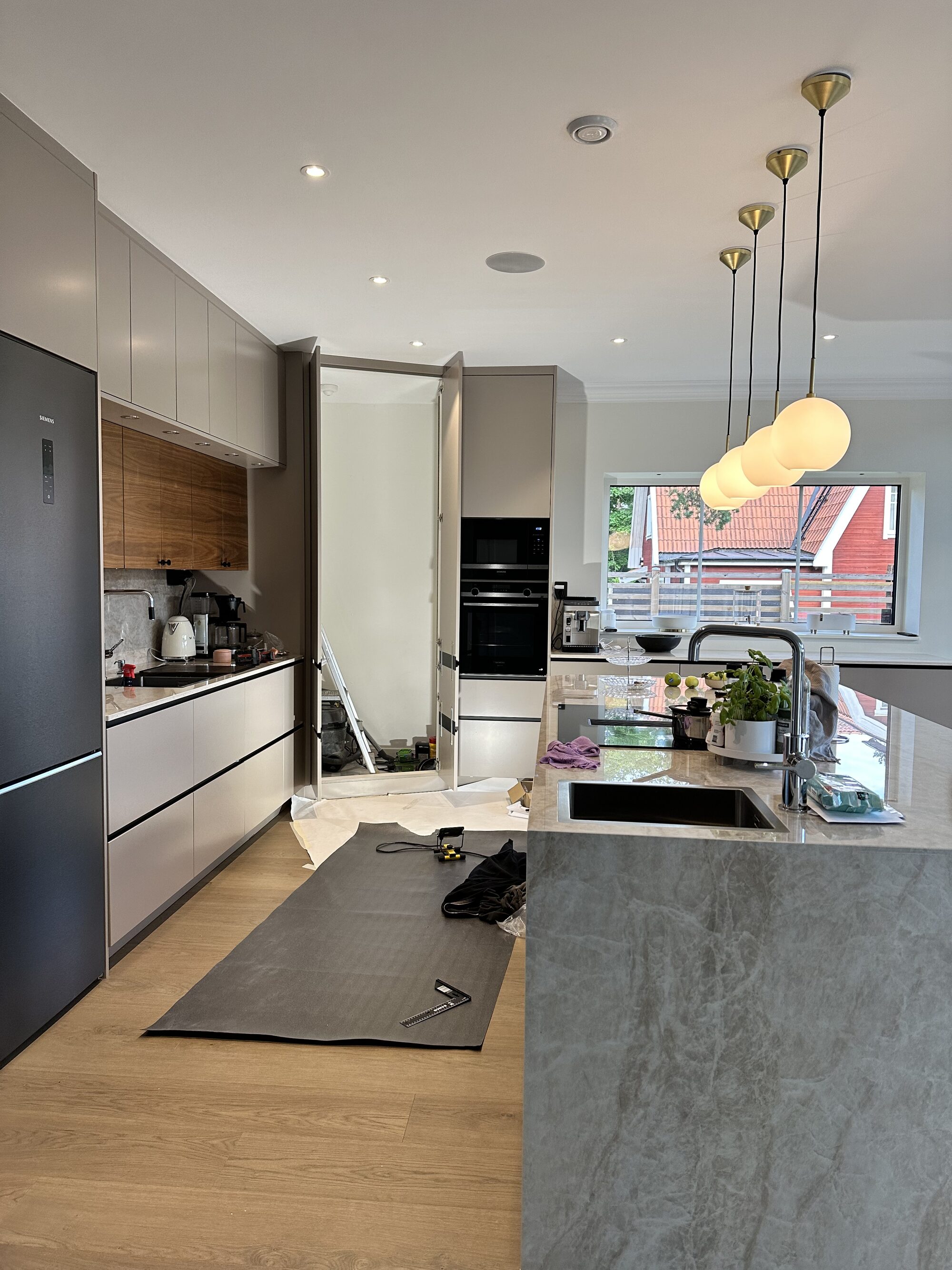 Kitchen with stone island and integrated appliances during the final fit-out stage