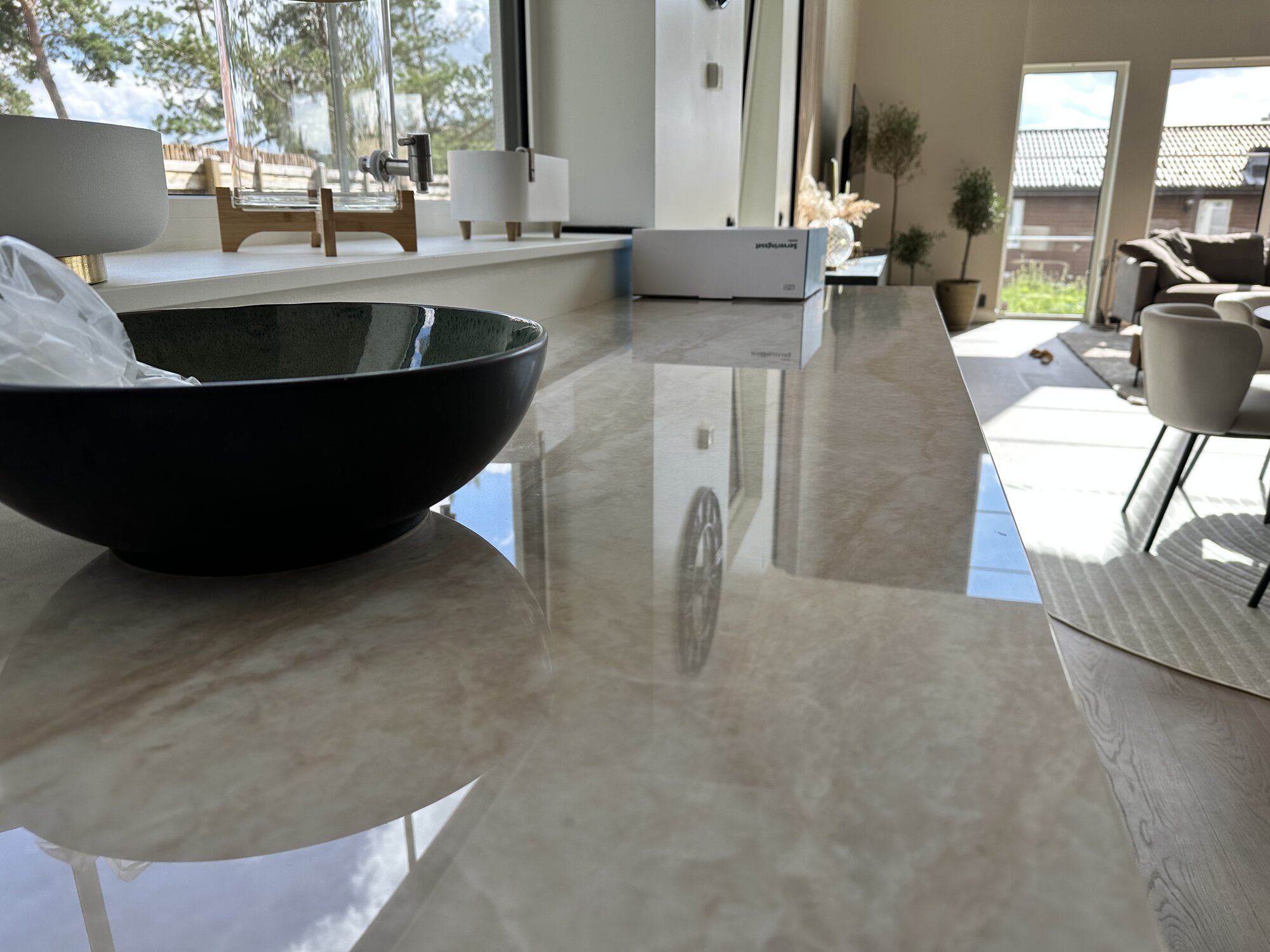 Polished stone worktop detail with the living area beyond