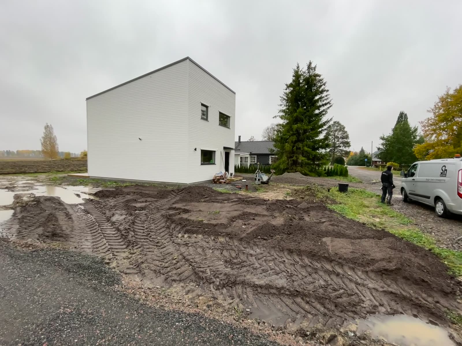 Graded plot and topsoil beside the completed two-storey house