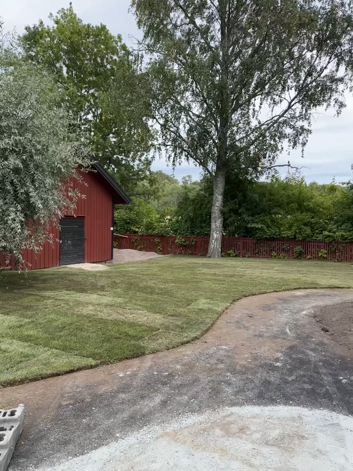 New turf and curved path beside the kindergarten outbuilding during groundworks