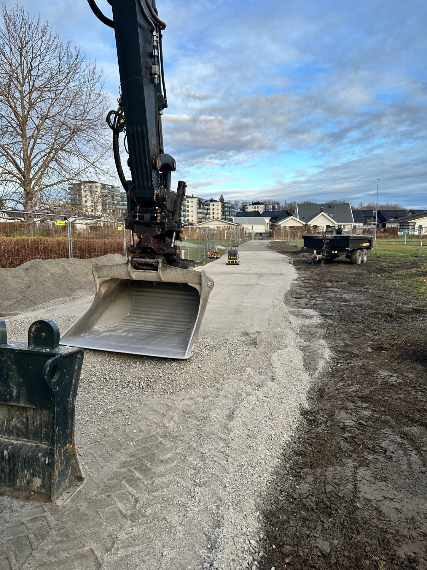 Excavator shaping the sub-base of a new pedestrian path