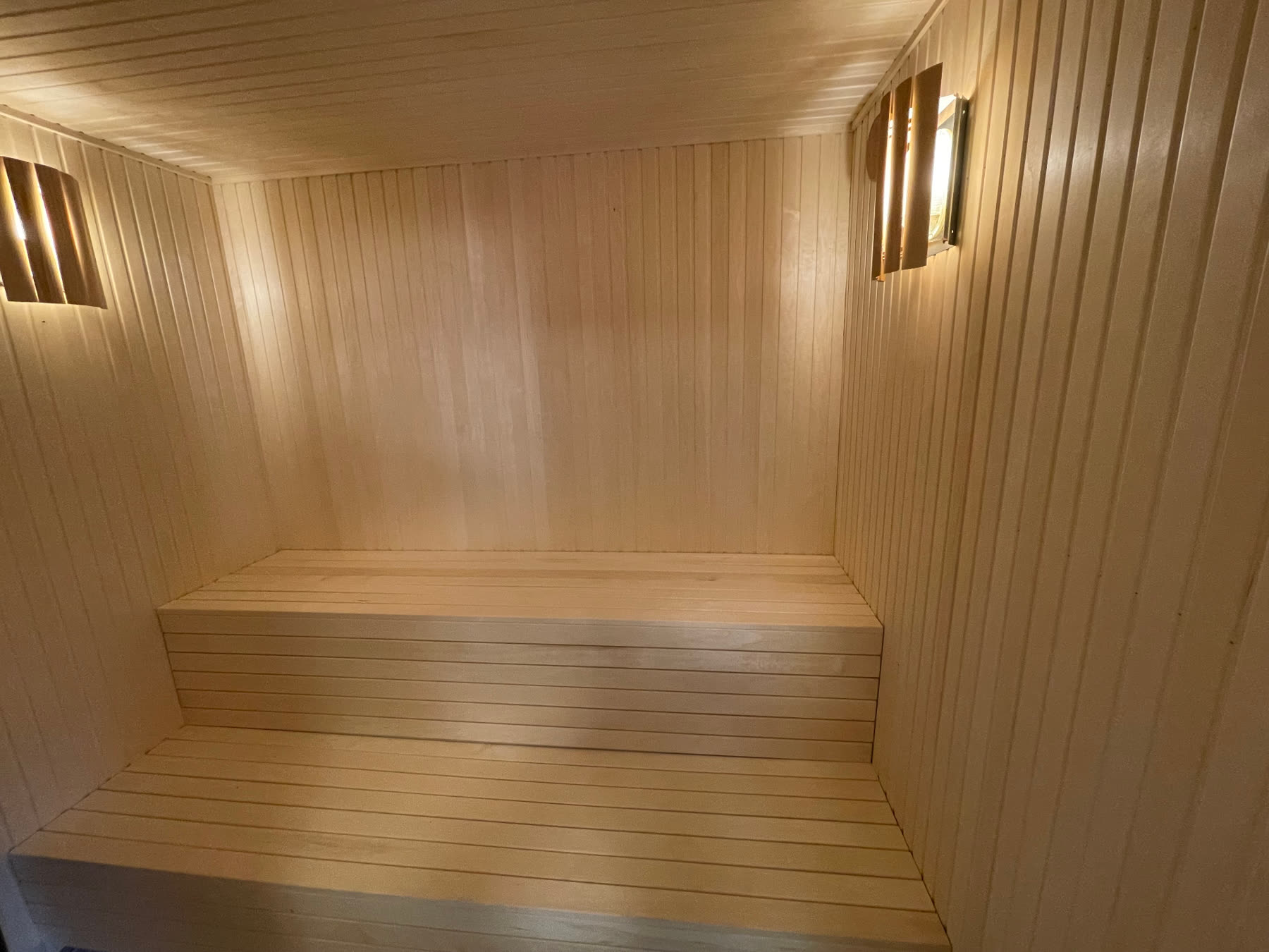 Two-tier sauna benching with shielded wall lights either side