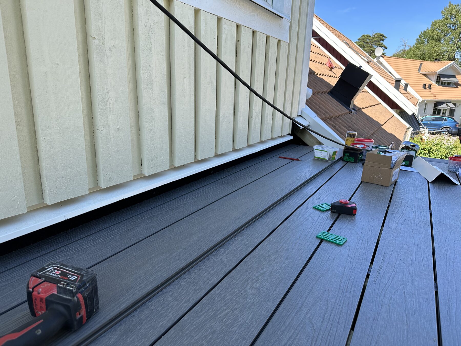 Composite decking boards being laid on a balcony with hidden fixing clips