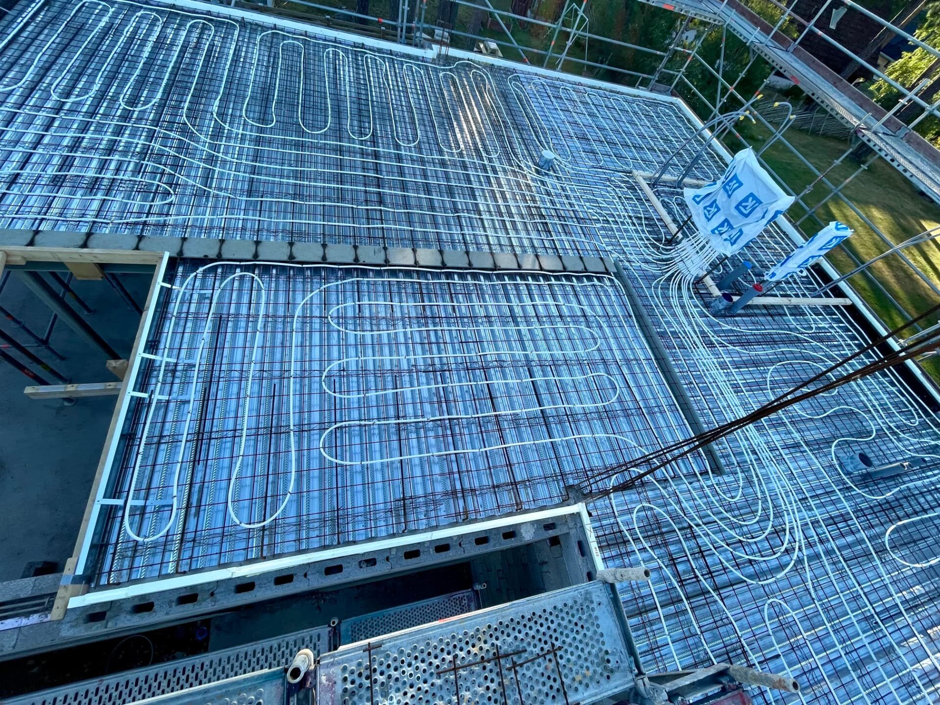 Water-based underfloor heating pipes clipped to reinforcement mesh before the screed pour