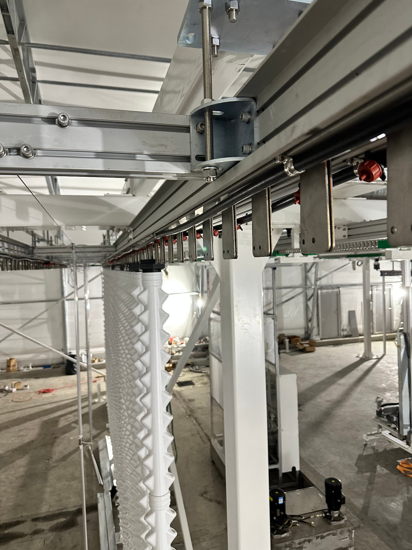 Aluminium conveyor run with hangers and irrigation lines above the towers