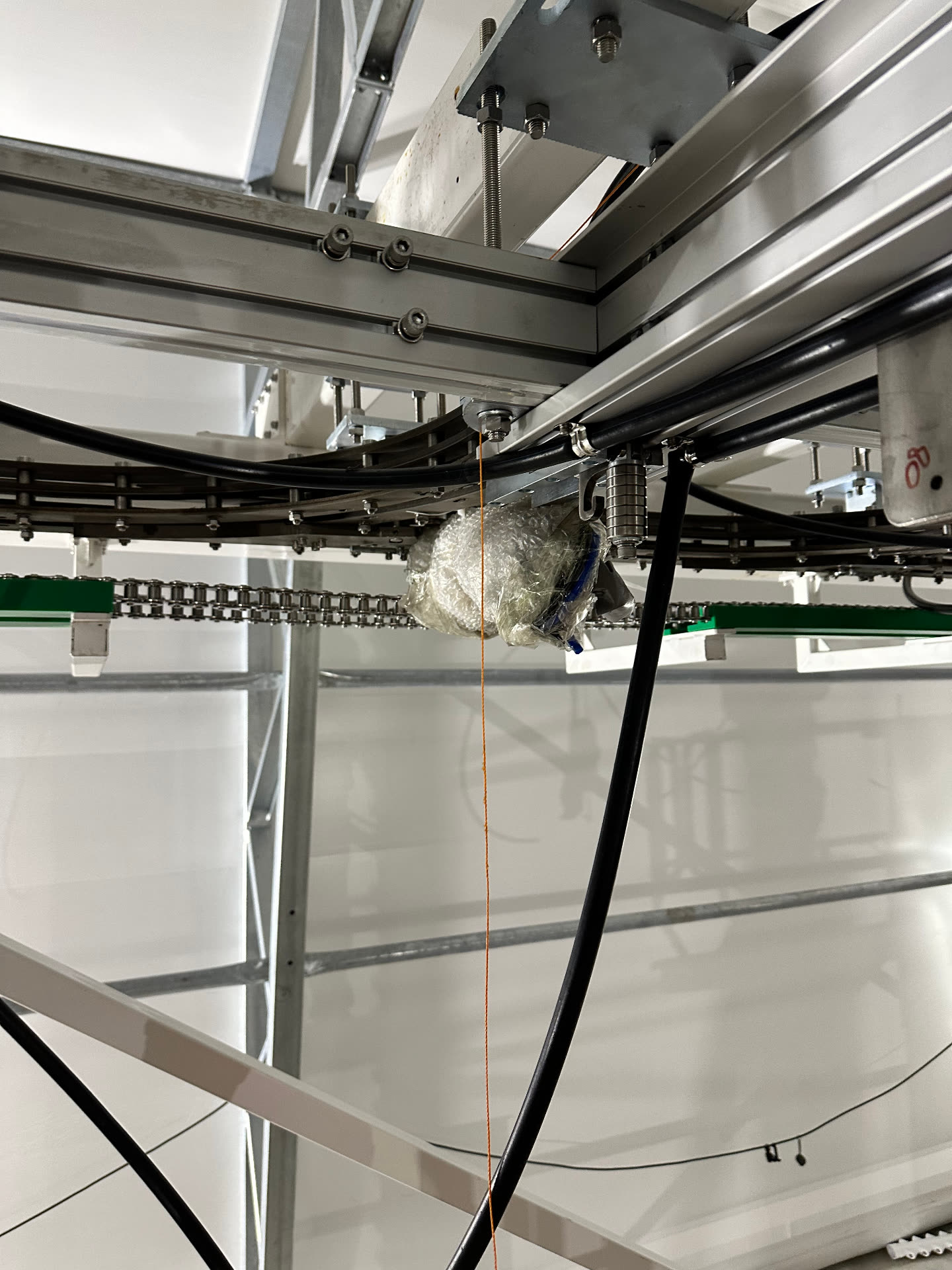 Chain drive and curved conveyor track detail under the roof structure