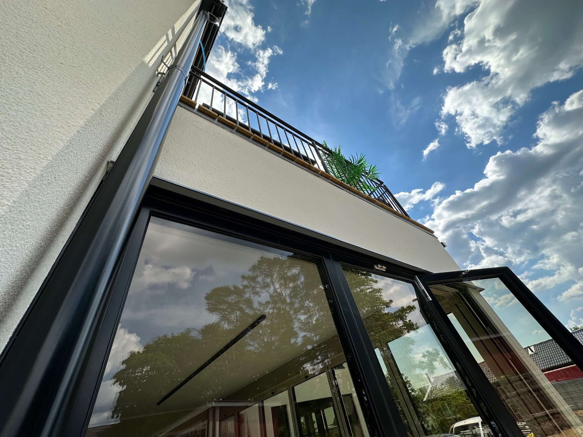Looking up at the timber-edged balcony above the ground-floor glazed doors