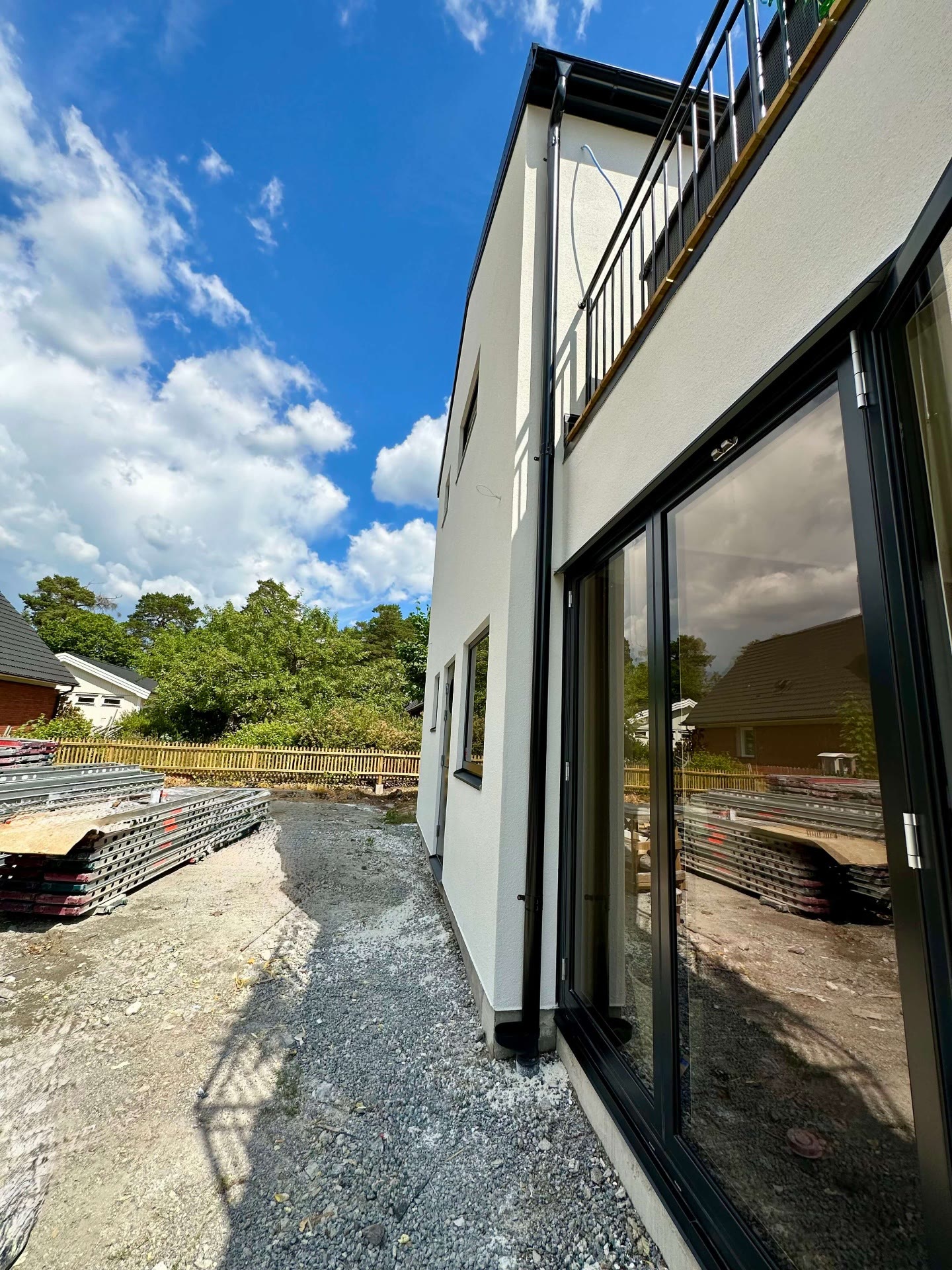Side elevation of the rendered villa with sliding glass doors and upper timber balcony