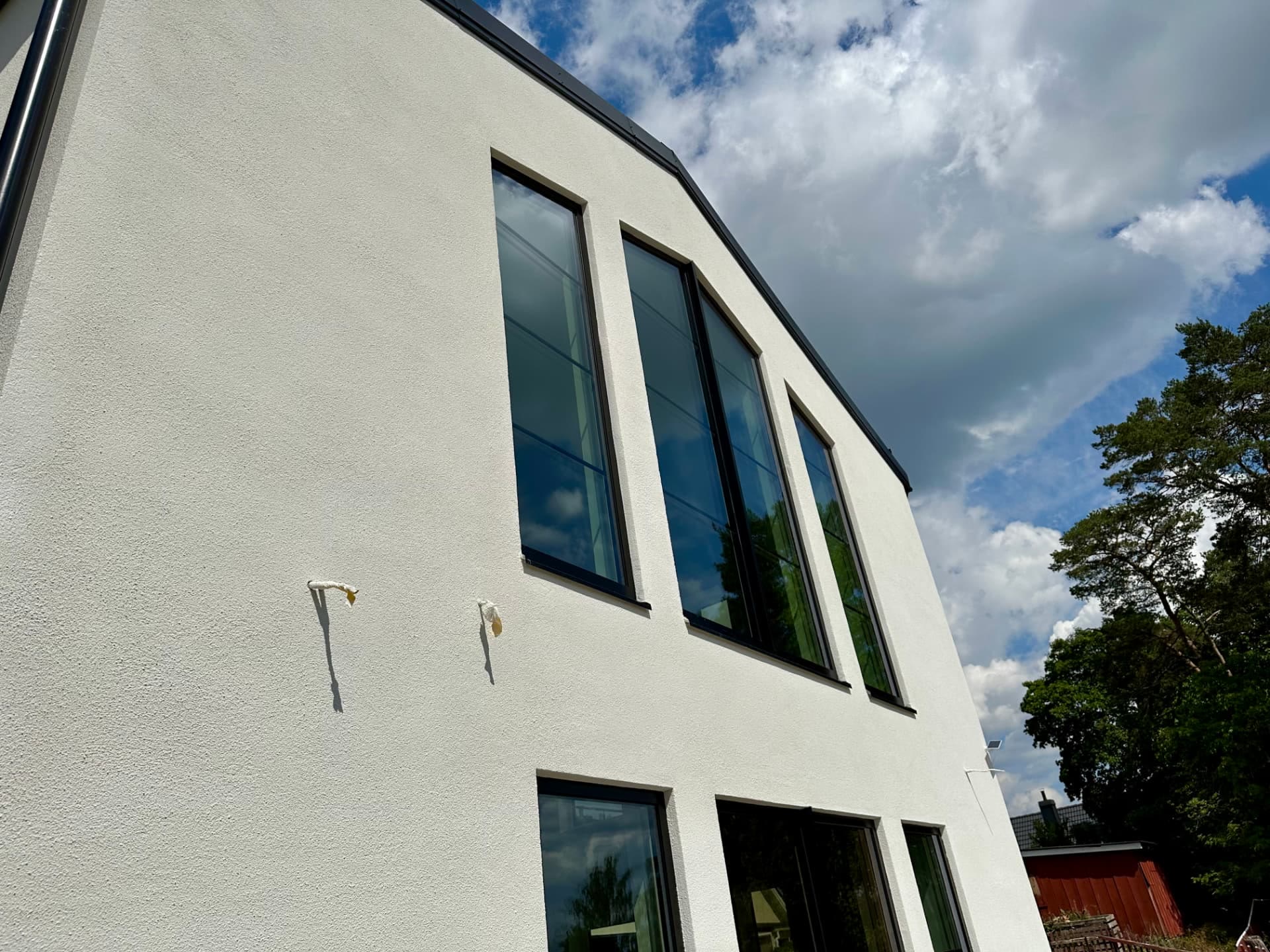 Row of tall windows set into the rendered facade of the villa