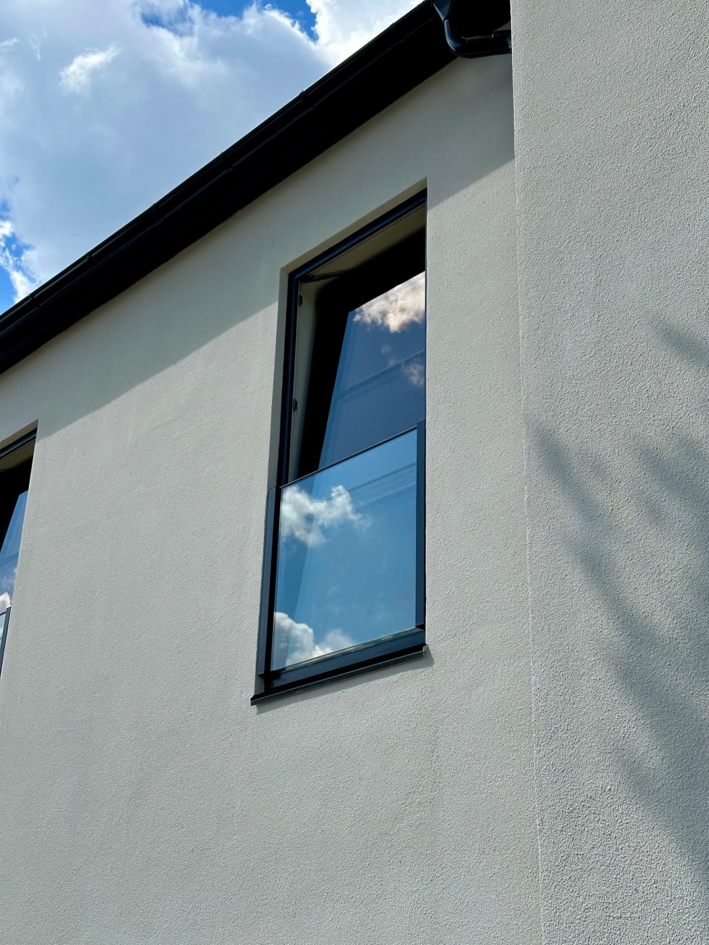 Close detail of a black-framed window in a crisp rendered reveal
